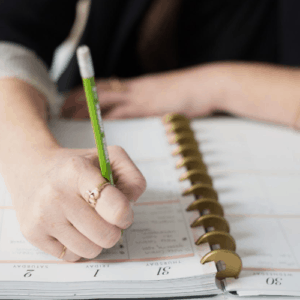 Planner writing in a notebook